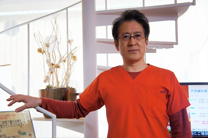 院長　戸田浩正が診療室で患者の資料を確認する様子