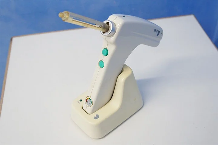 歯科診療で使用する機器をスタッフが操作前に確認している手元