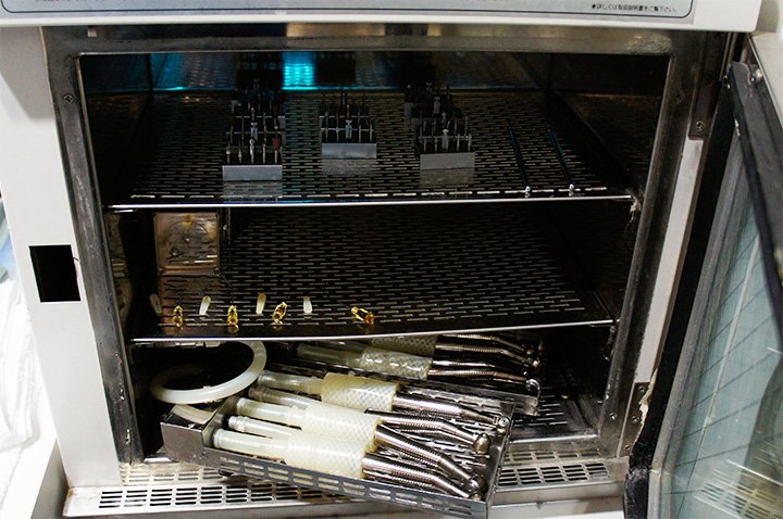 歯科診療で使用する機器をスタッフが操作前に確認している手元