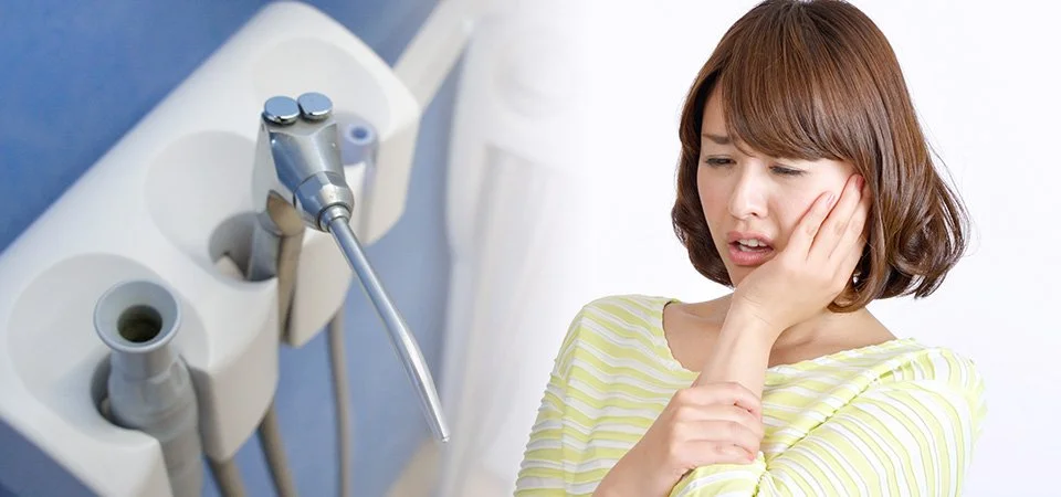 歯科医師が診療台で患者の口元を確認しながら説明する様子
