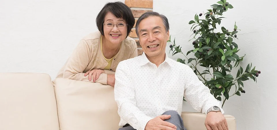 歯科医師が診療台のそばで患者の口元の状態を確認しながら説明する様子