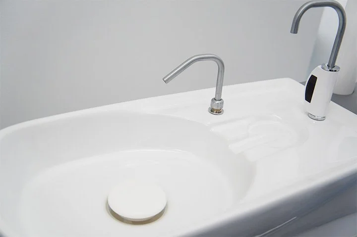 歯科診療台の横で治療の準備をするスタッフの手元